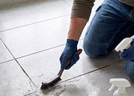 Man using WSGenie grout cleaning brush on bathroom tile joints