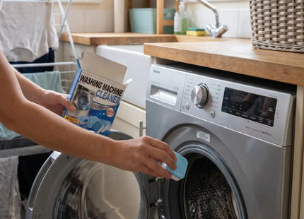 Woman dropping a WSGenie cleaner tablet into a washing machine drum
