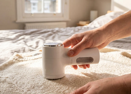 Person removing bobbles from a jumper with the WSGenie electric fabric shaver