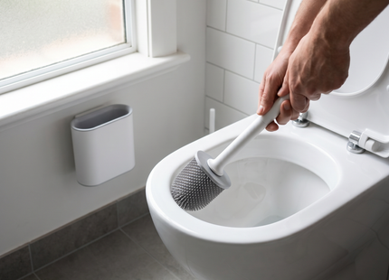 Person cleaning a toilet with the WSGenie silicone toilet brush