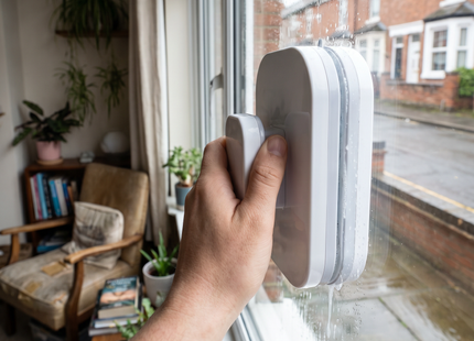 Person cleaning a window with the WSGenie double-sided magnetic window cleaner